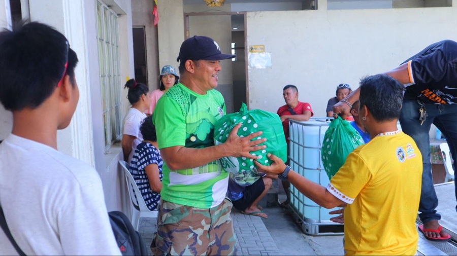 A resident affected by Typhoon Uwan receives a Kalinga Pack from the volunteers in SM City Consolacion.